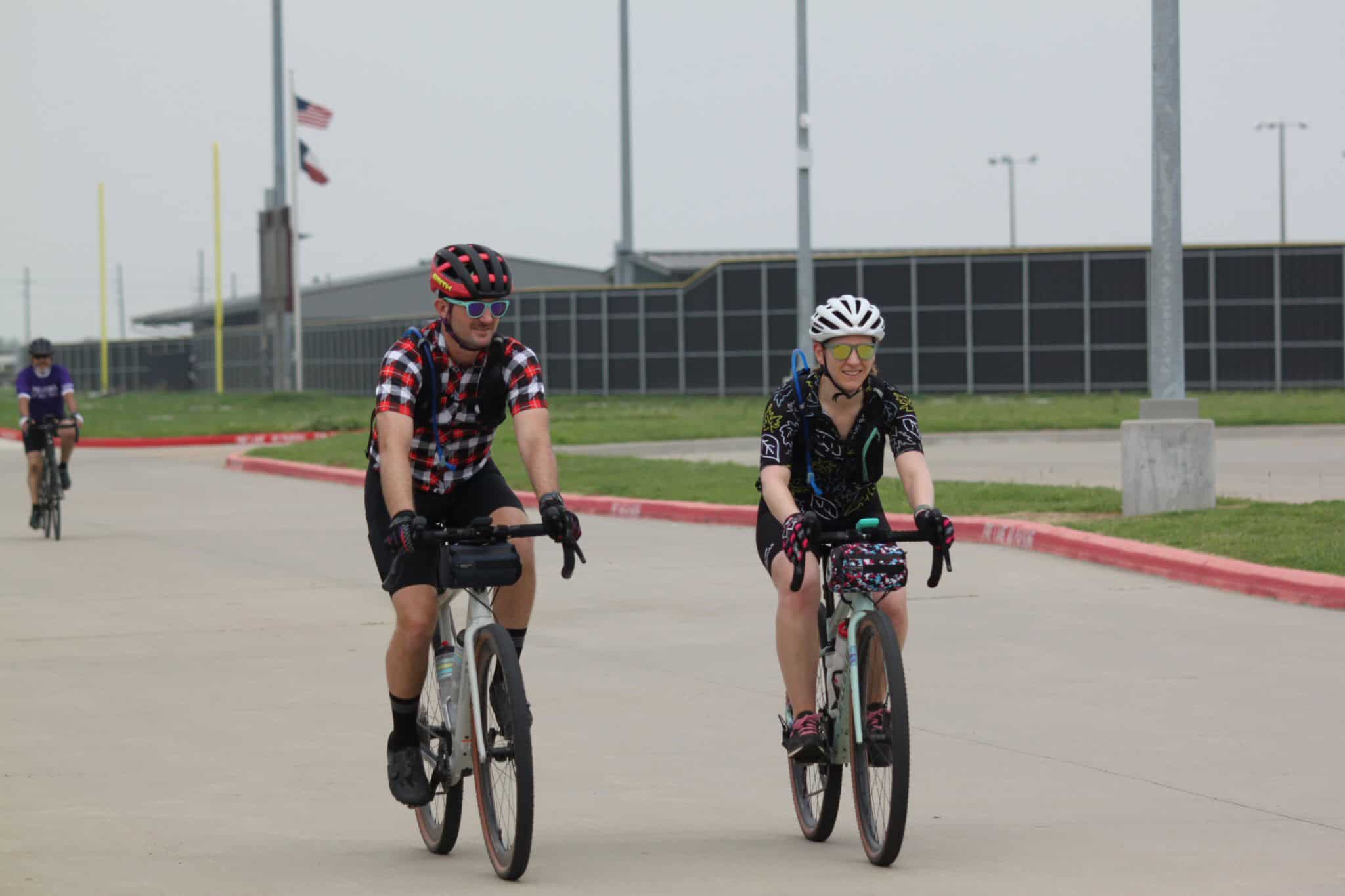 Brightly colored cyclists riding near Bluebonnet Express stadium in Houston, TX, outdoor cycling fun.