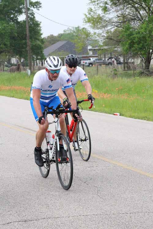 Riders cycling on a scenic open road during Bluebonnet Express event in Texas.