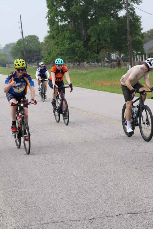 Bicycle group ride on a scenic rural road, promoting active lifestyle and outdoor adventure.