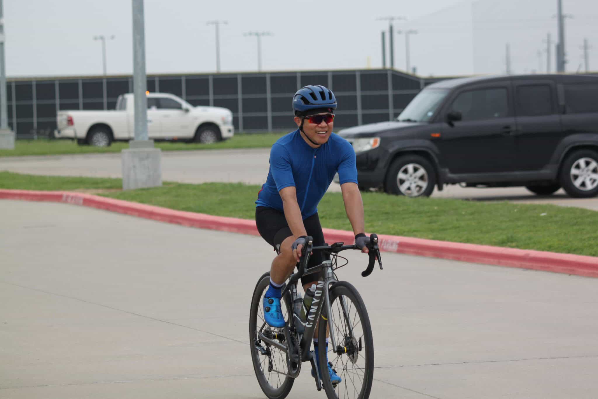 Bright blue cyclist gear on a man riding a Canyon road bike during daytime.