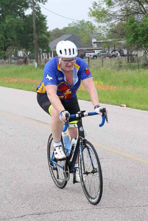 Bright cyclist riding a road bike during Bluebonnet Express event, promoting active lifestyles and outdoor fitness.