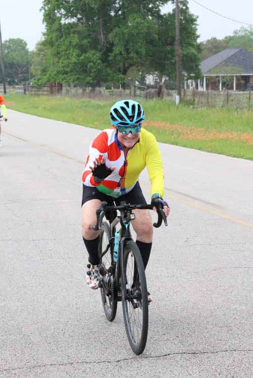 Colorful cyclist riding on the road during Bluebonnet Express event.