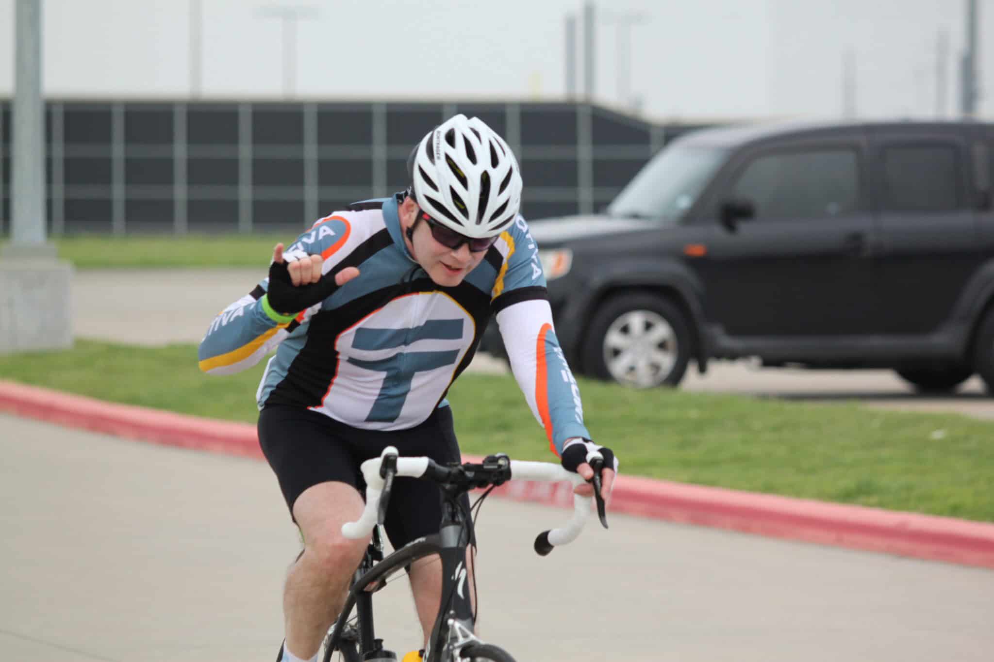 Cyclist wearing Bluebonnet Express jerseys riding passionately during a race event.