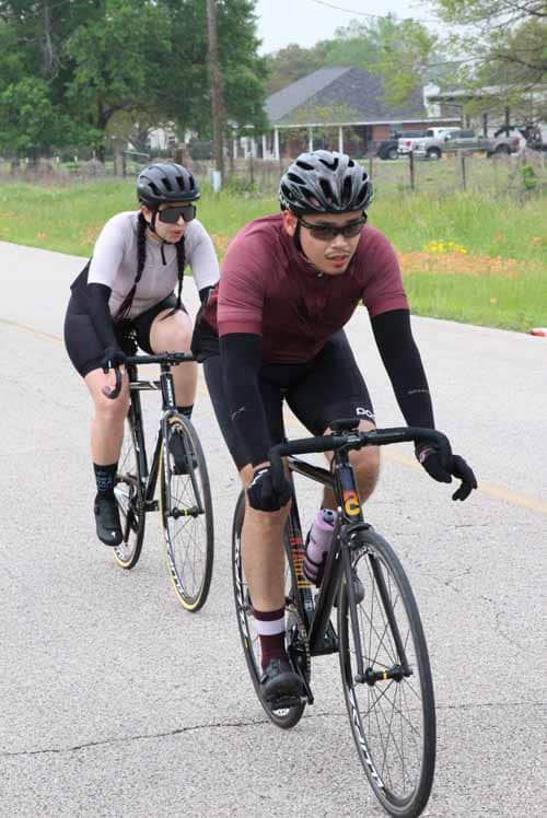 Kids biking on a scenic trail with helmets and cycling gear during daytime.