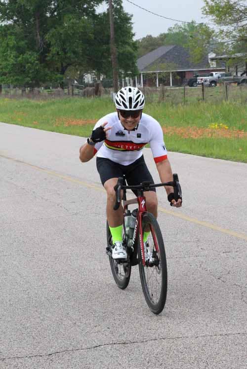 High-performance cyclist enjoying a ride on a rural road, showcasing endurance and passion for outdoor cycling.