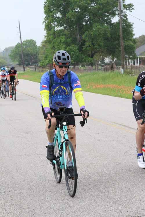 Rider participating in Bluebonnet Express cycling event, wearing helmet and colorful cycling gear.