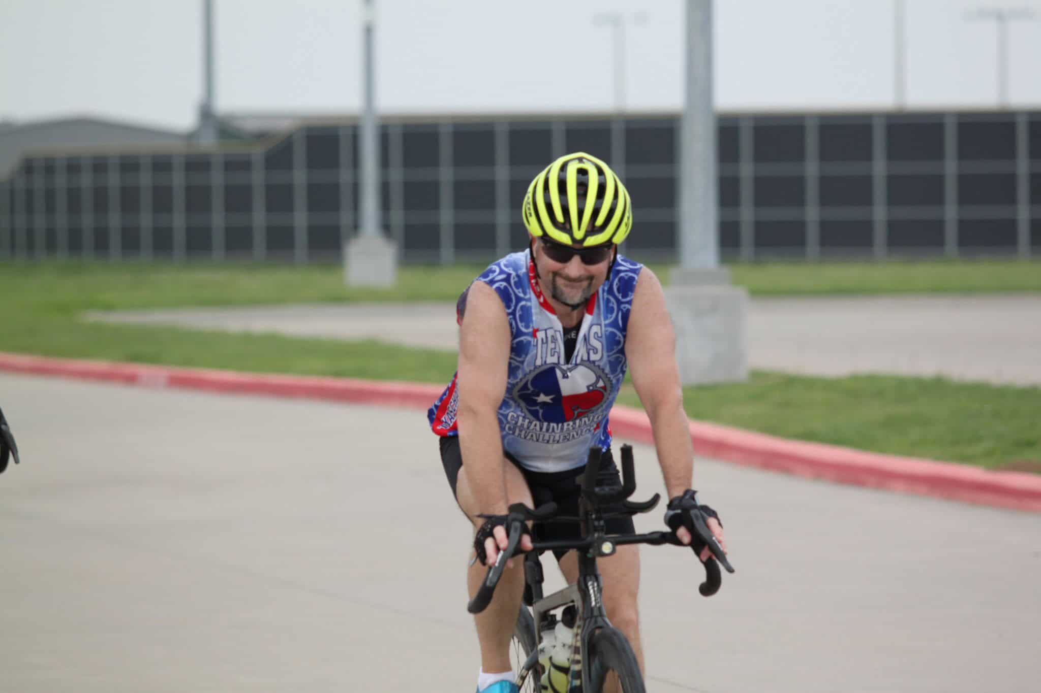 Velo cyclist wearing Bluebonnet Express jersey, riding on a scenic Texas route.