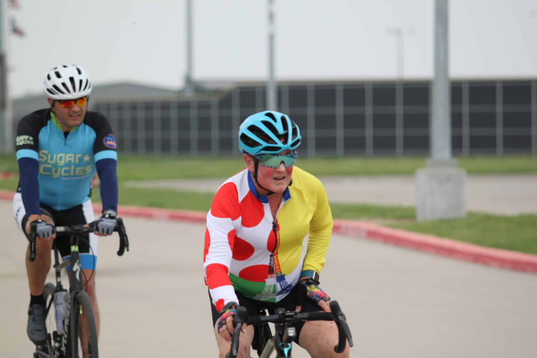 Older cyclist wearing a colorful jersey on a Bianchi bike at Bluebonnet Express event.