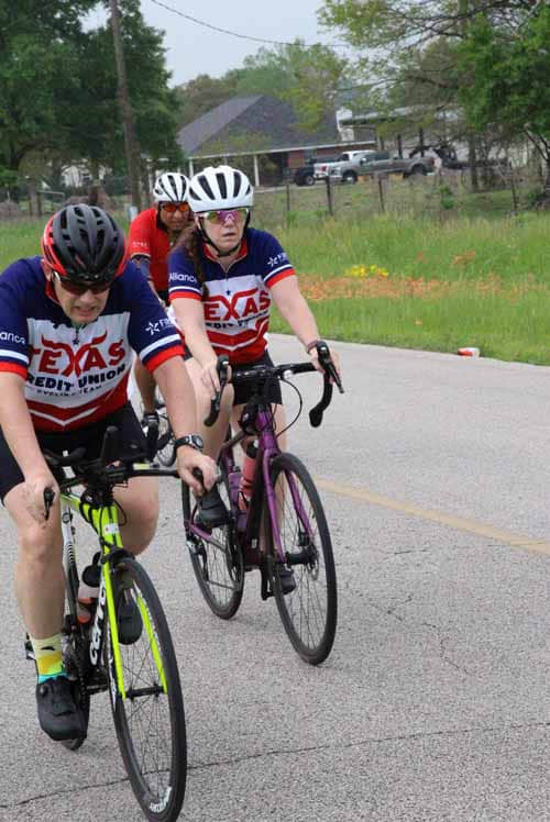 Cyclists riding together on a scenic road during Bluebonnet Express event.