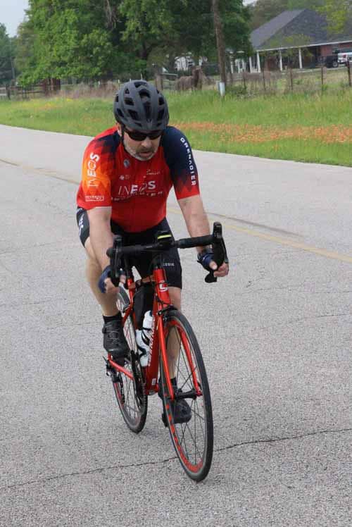Man riding red road bike during Bluebonnet Express cycling event.