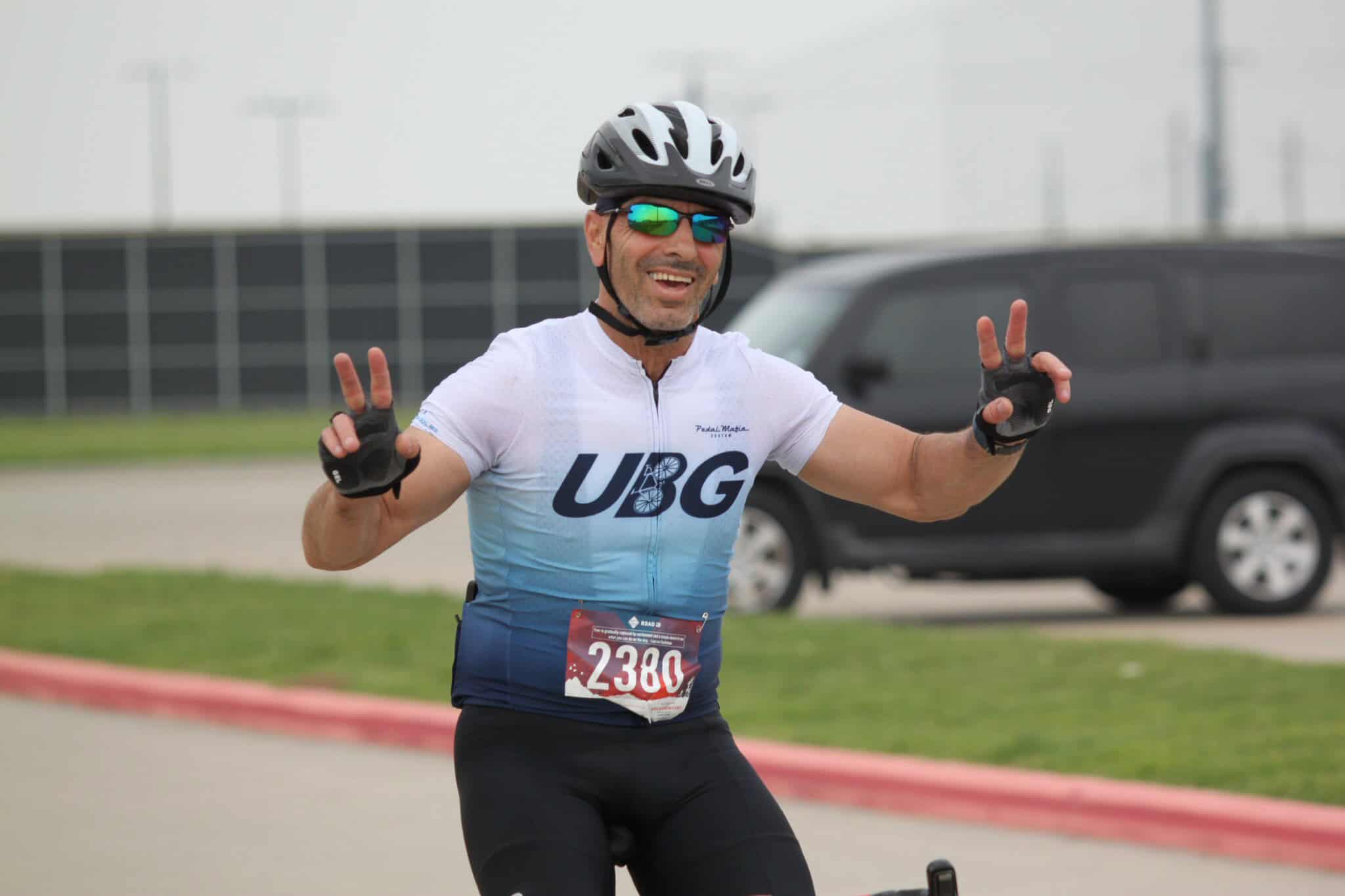 Vibrant cyclist celebrating victory at Bluebonnet Express race event, showcasing athleticism and team spirit.