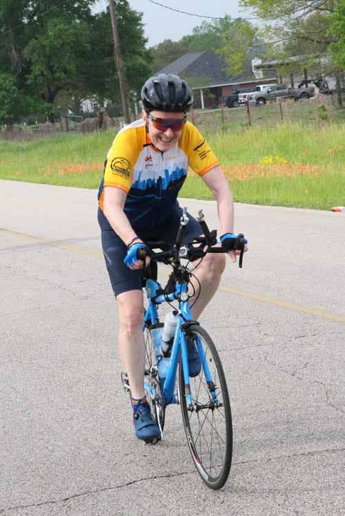 Bright cyclist enjoying Bluebonnet Express bike ride in scenic outdoor setting.