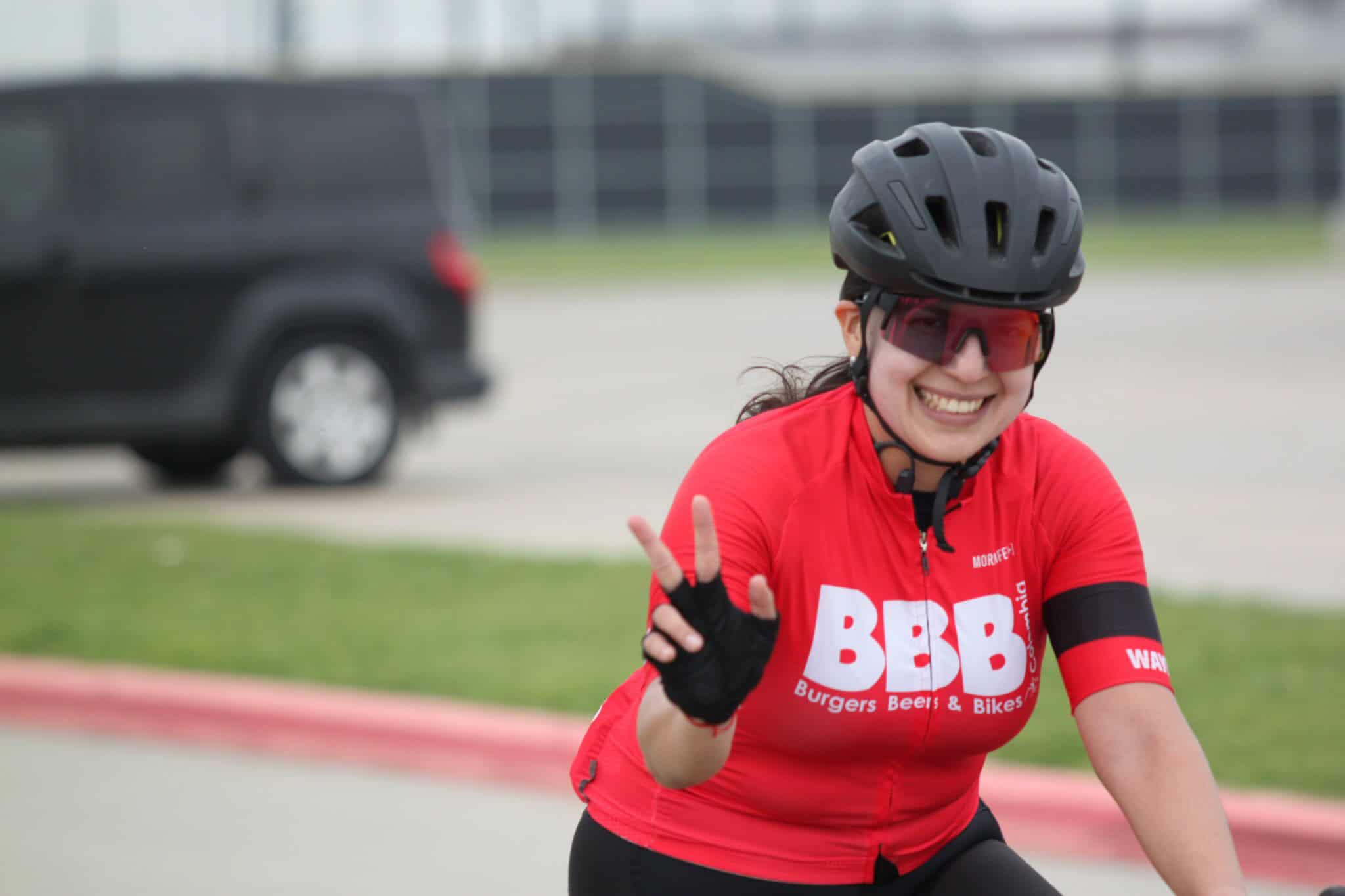 Women cycling with helmet and sunglasses, promoting Bluebonnet Express bike services.
