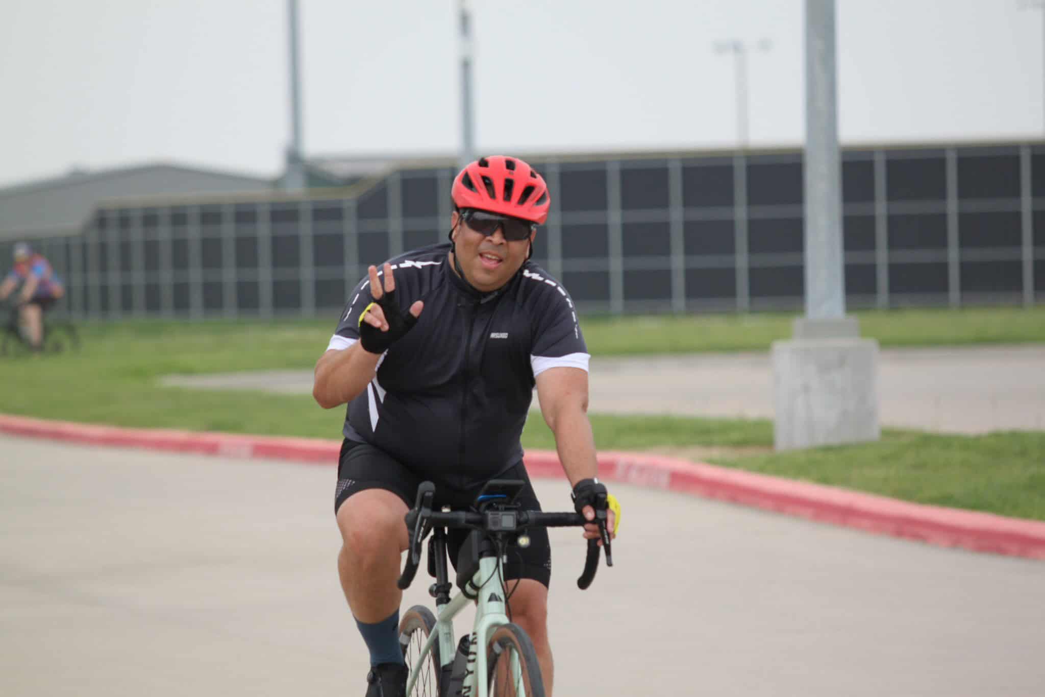 Vibrant cyclist wearing a red helmet and black cycling gear on the Bluebonnet Express route.