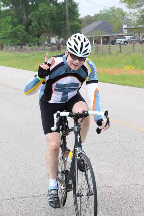 Bright cyclist in blue jersey riding on the road enjoying Bluebonnet Express event.