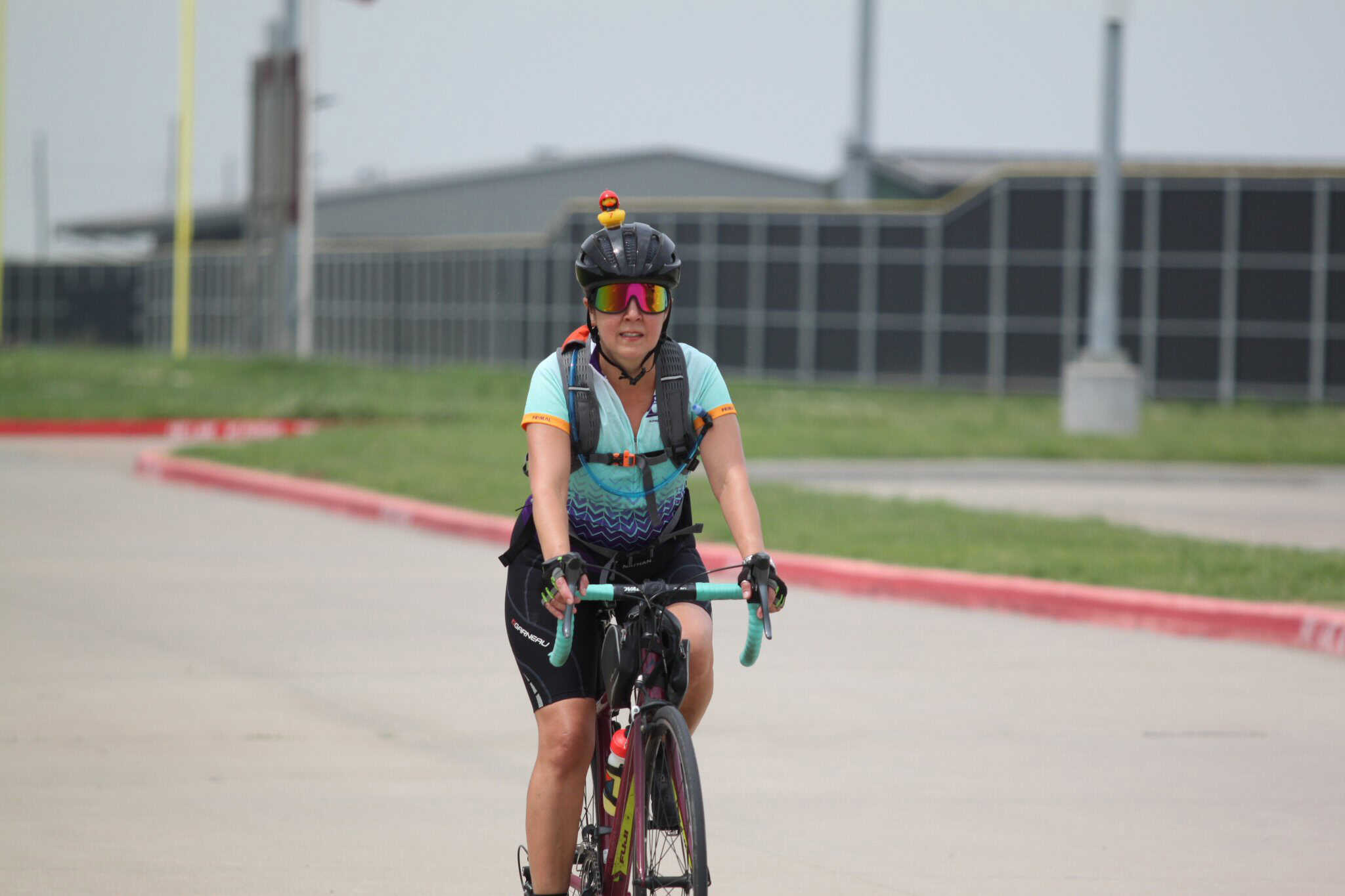 Bright cyclist wearing helmet and sunglasses, promoting Bluebonnet Express bike rides.
