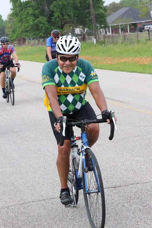 Smiling cyclist riding during Bluebonnet Express event on a rural road.