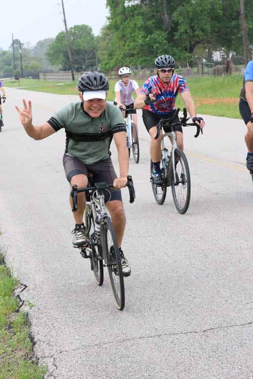 Happy cyclist making peace sign during Bluebonnet Express bike ride event.