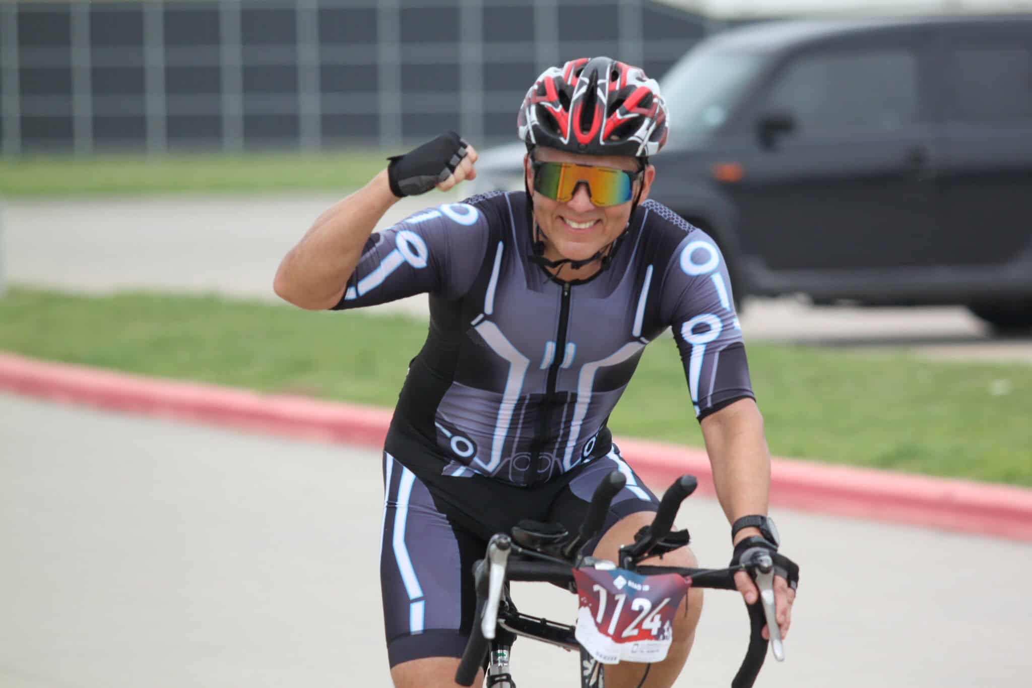 Vibrant cyclist in futuristic gear riding during Bluebonnet Express event.