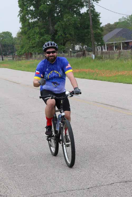 Enjoying a scenic bike ride with Bluebonnet Express cycling gear on a peaceful road in Texas.