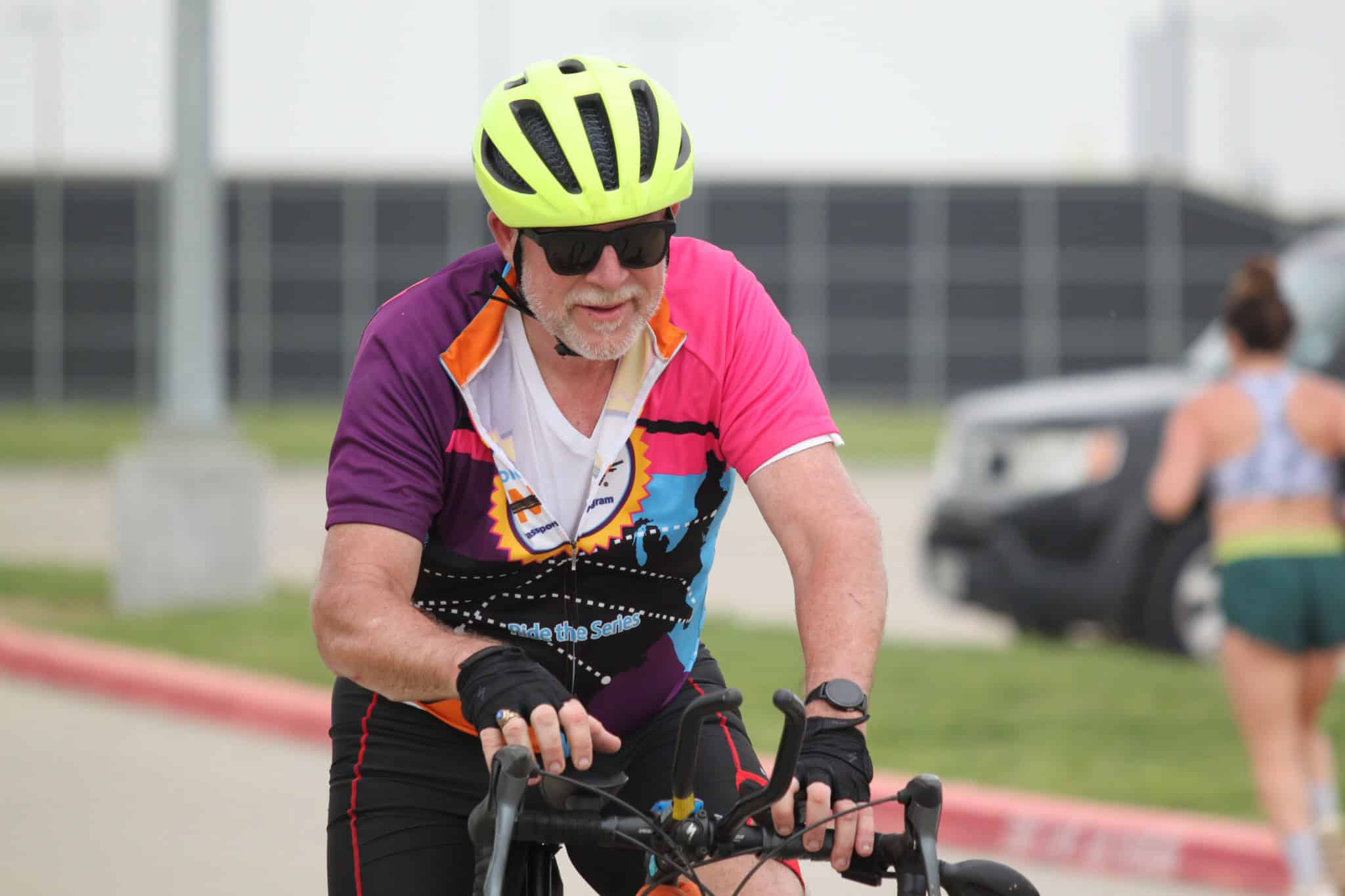 Vibrant cyclist wearing a neon yellow helmet and colorful jersey during Bluebonnet Express ride.