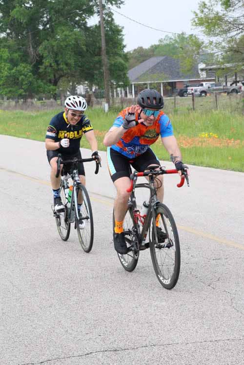 Brightly dressed cyclists enjoying a ride on a rural road during daytime.