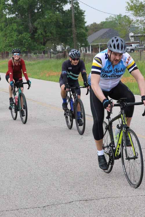 Bike riders on a rural road during daytime for Bluebonnet Express event.