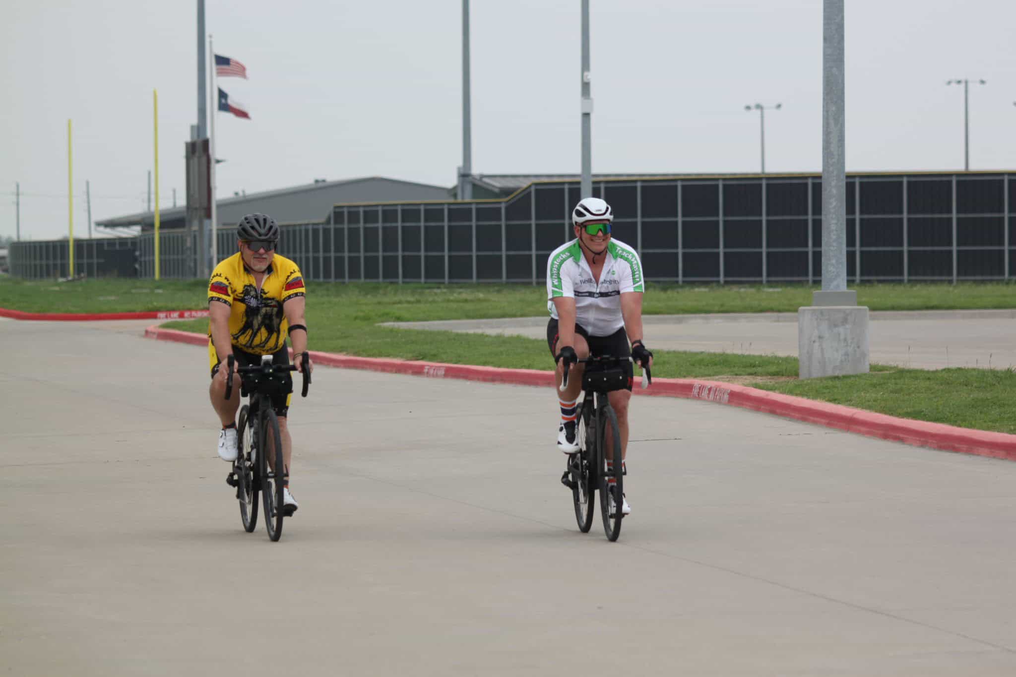 Brightly dressed cyclists riding on a paved road in a cycling event, showcasing Bluebonnet Express Bike Ride.