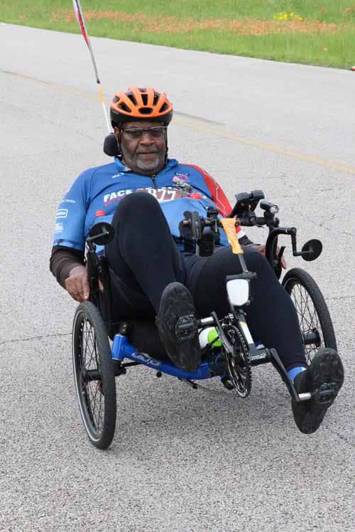 1. Man riding a handcycle bike outdoors for adaptive cycling and fitness.