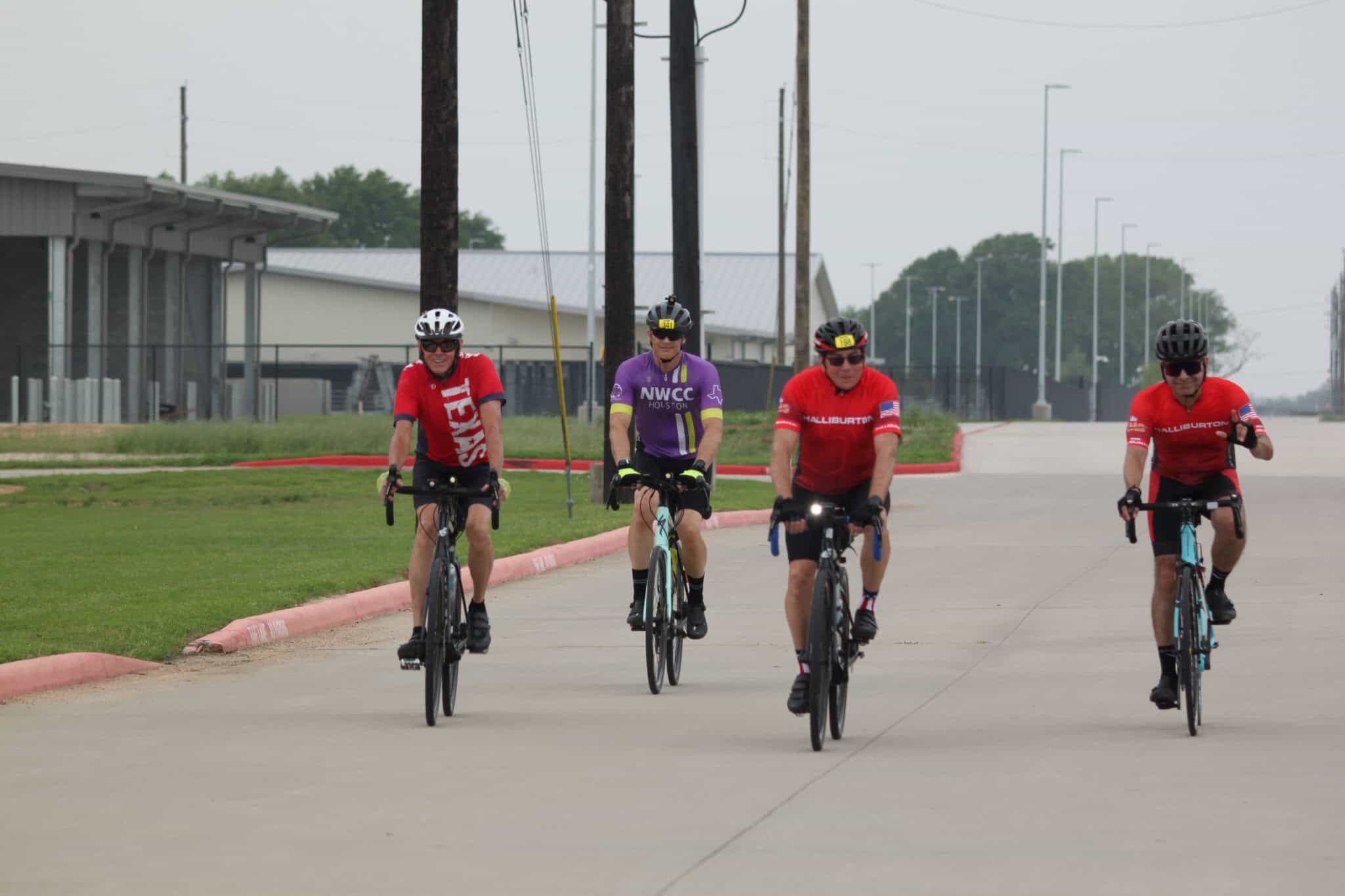 Brightly dressed cyclists enjoying a group ride outdoors on a cloudy day for Bluebonnet Express event.