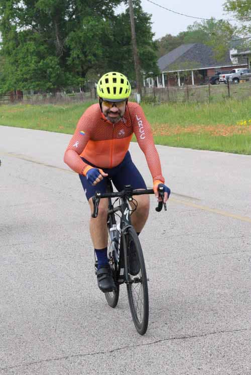Yellow helmet cyclist riding on rural road for Bluebonnet Express event.