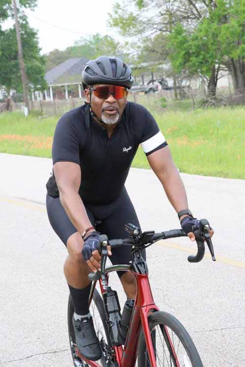 Men cycling on the street in bike gear with helmet and sunglasses, outdoor sports activity.