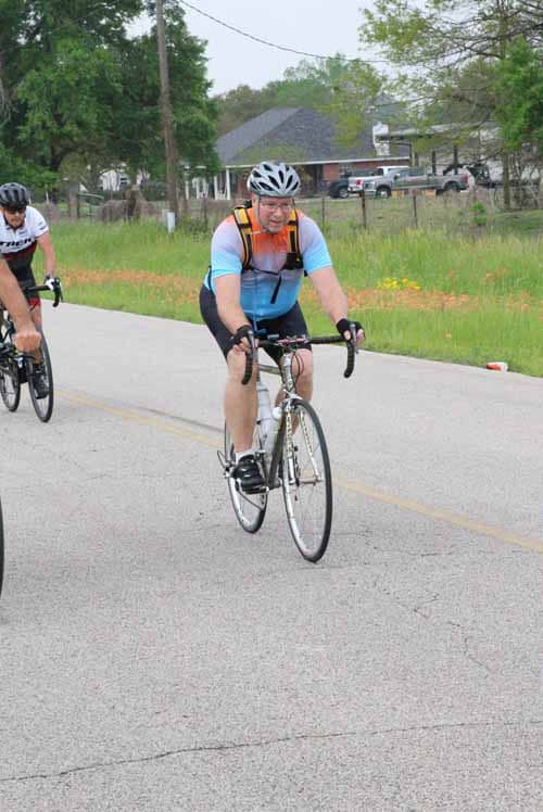 Bright cyclist riding along the road during Bluebonnet Express event in Texas.