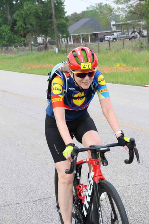 Bright female cyclist riding mountain bike during Bluebonnet Express event in Texas.