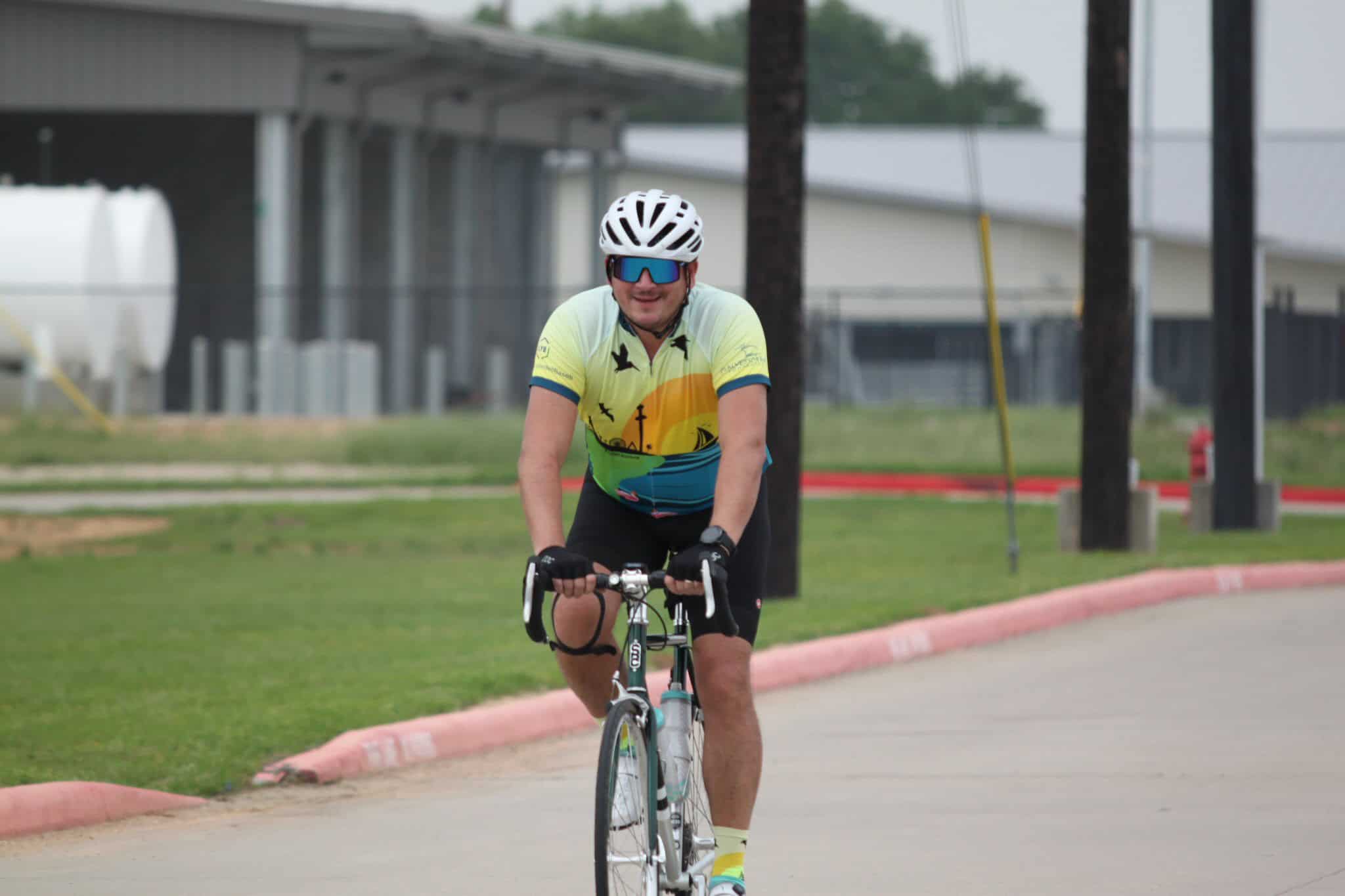 Vibrant cyclist wearing a colorful jersey on a scenic bike ride at Bluebonnet Express event.