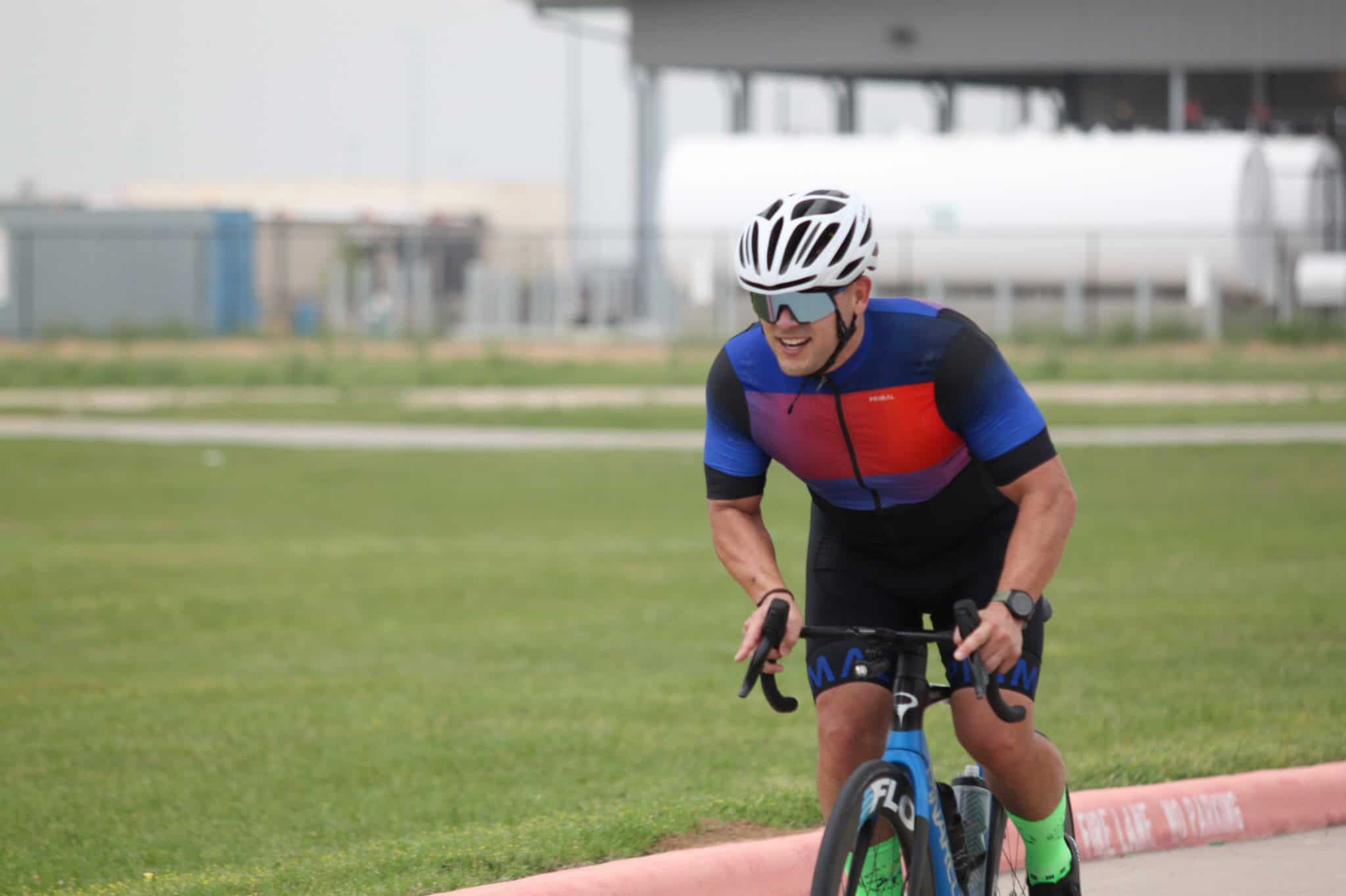 Vibrant cyclist riding towards finish line on Bluebonnet Express bike route outdoor event.