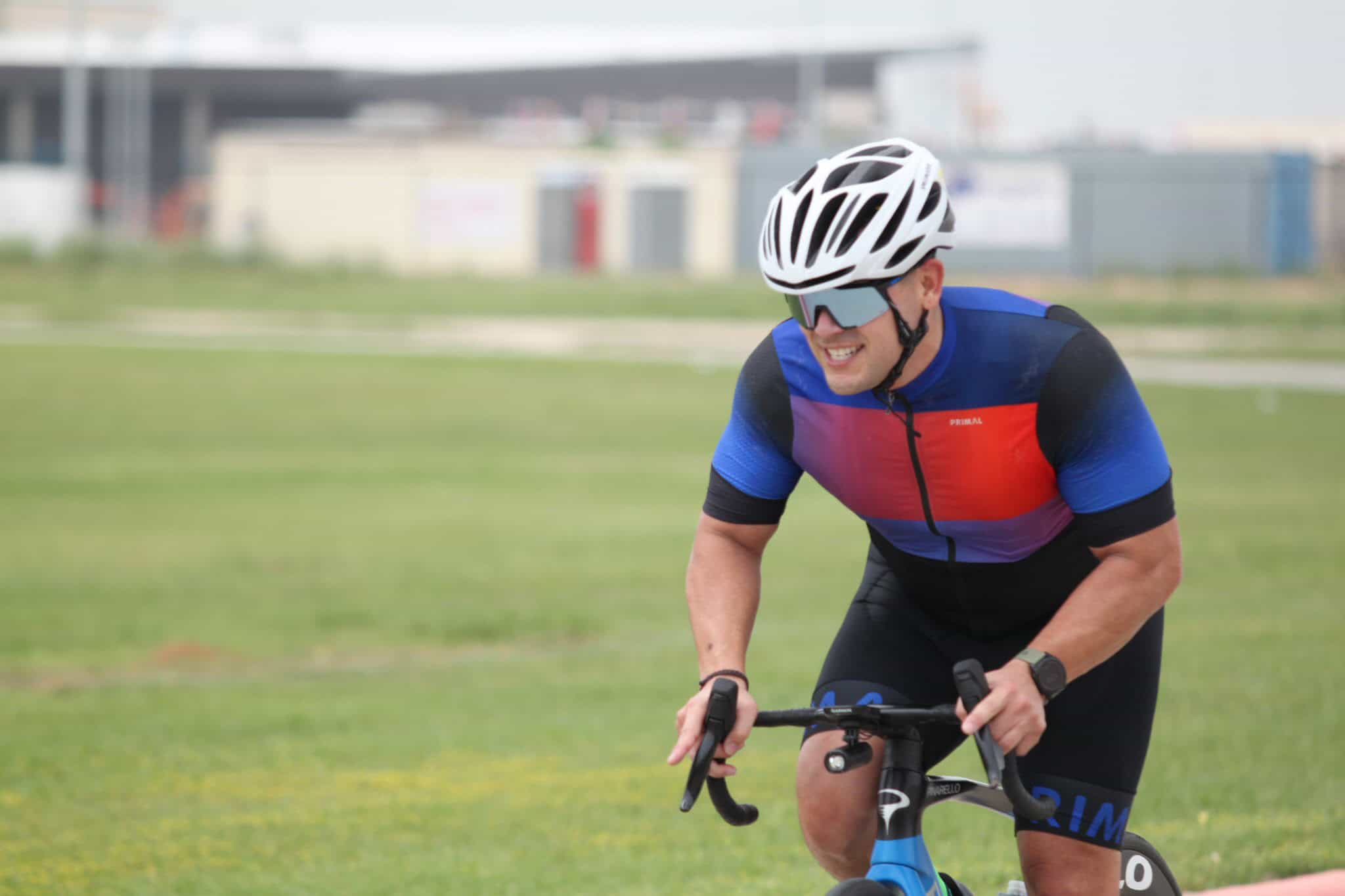 Vibrant cyclist riding outdoors on a blue road bike during daytime.