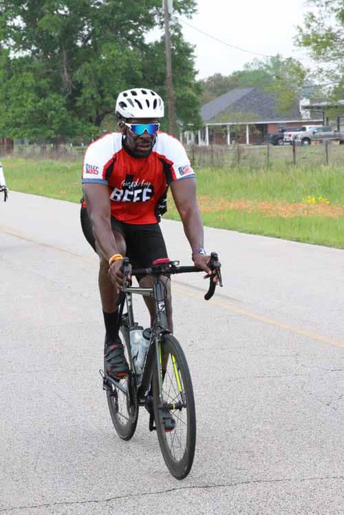 Bright cyclist riding on rural road during Bluebonnet Express event, emphasizing outdoor biking and community cycling.