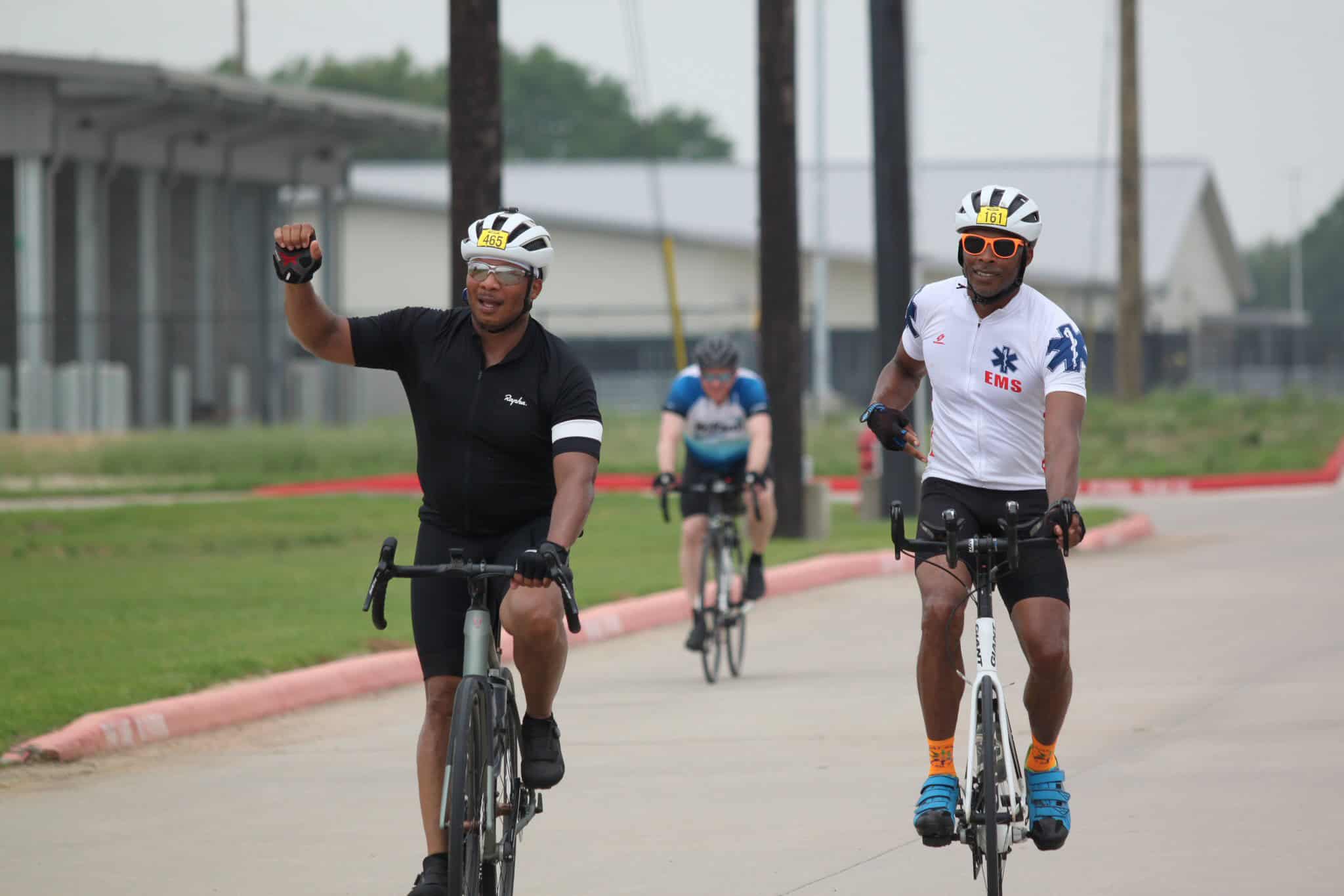 Vibrant cyclists riding on the road during a Bluebonnet Express cycling event.
