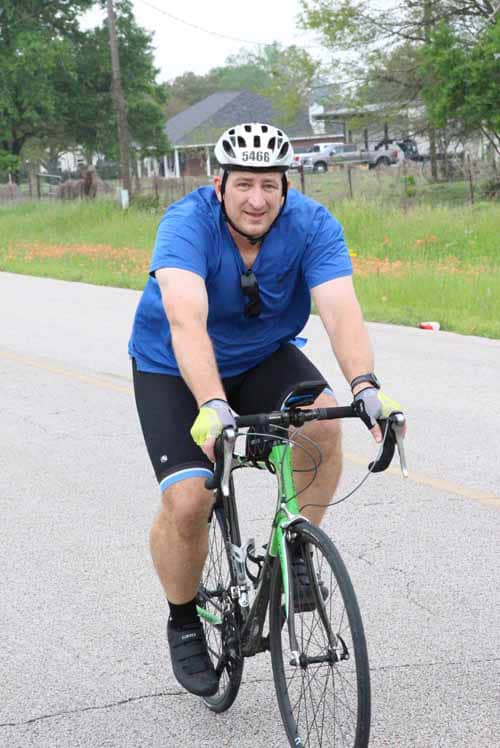 Active cyclist in Bluebonnet Express event riding a bike outdoors in Texas.