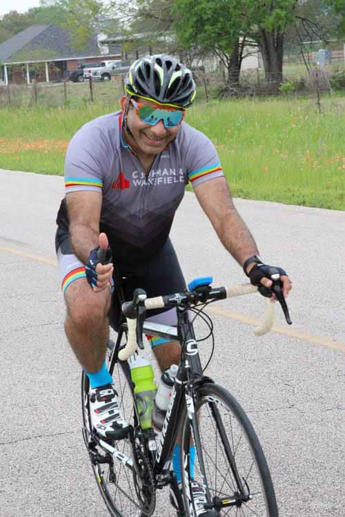 Bright cyclist in colorful uniform riding a road bike during Bluebonnet Express event.