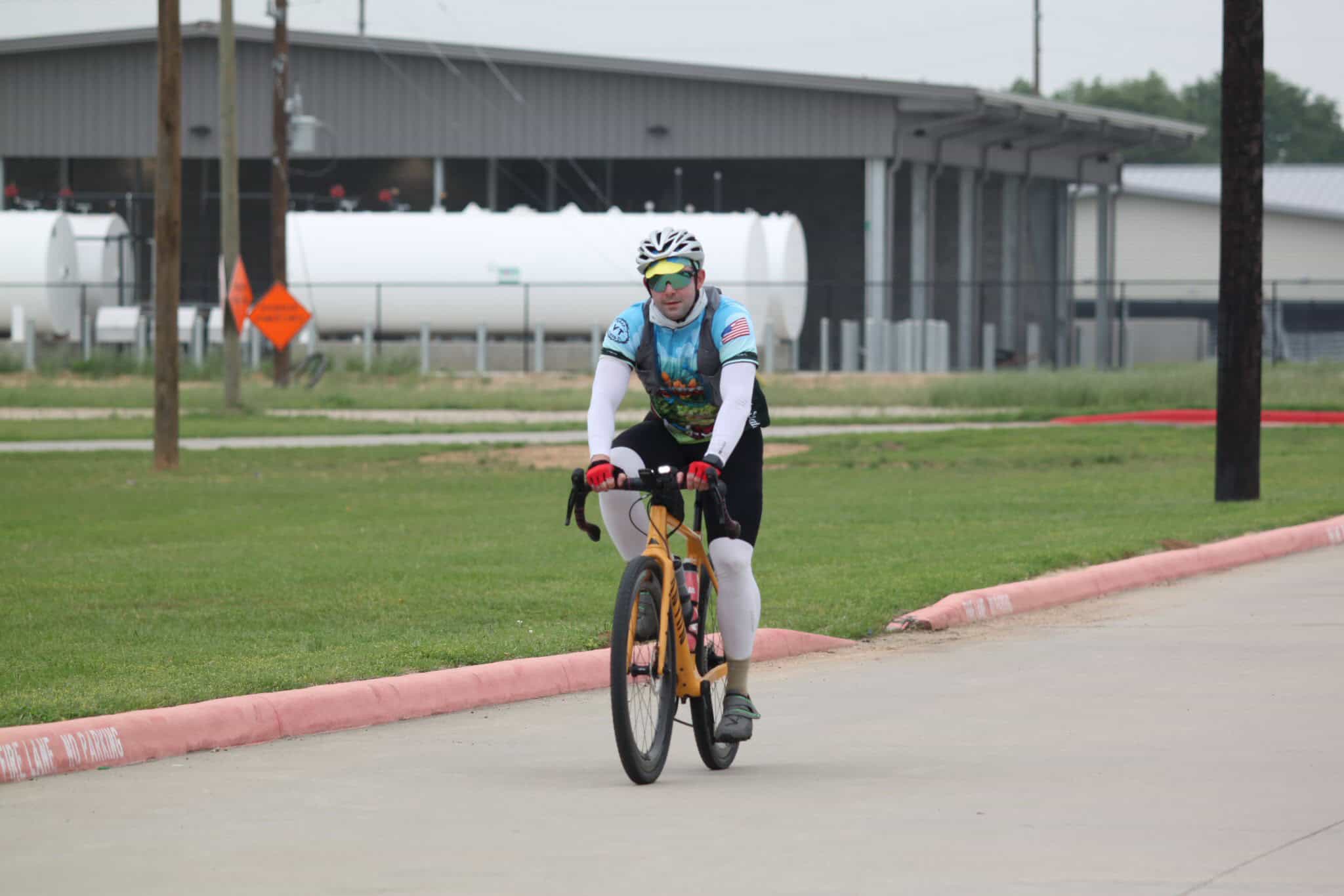 Vibrant cyclist riding on a bike path during daytime featuring Bluebonnet Express branding.