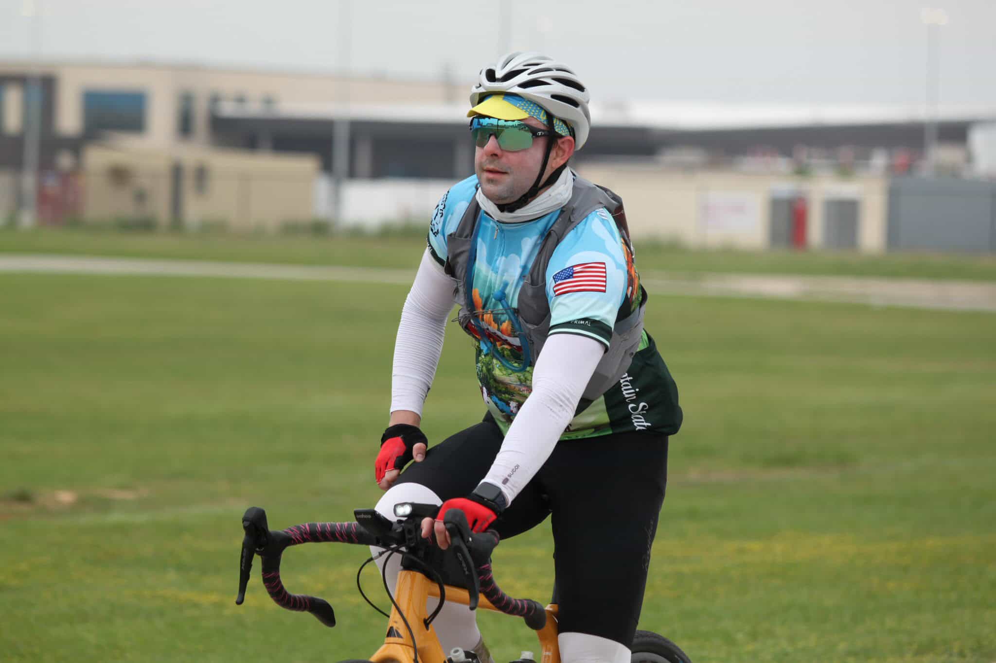 Bright cyclist wearing a helmet and sports gear on a yellow bike outdoors.