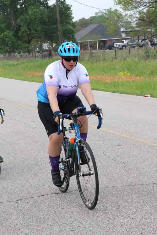 Bike rider in Bluebonnet Express cycling event wearing helmet and cycling gear.