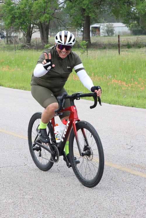 Vibrant cyclist on red road bike enjoying outdoor ride in a scenic park environment.