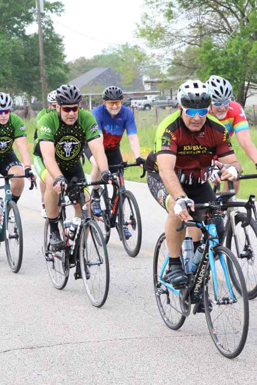 Bright mountain bikers cycling together during Bluebonnet Express event in Texas.