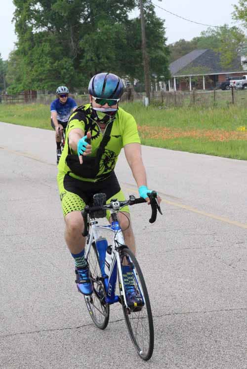 Vibrant cyclist wearing bright gear on Bluebonnet Express route during day ride.