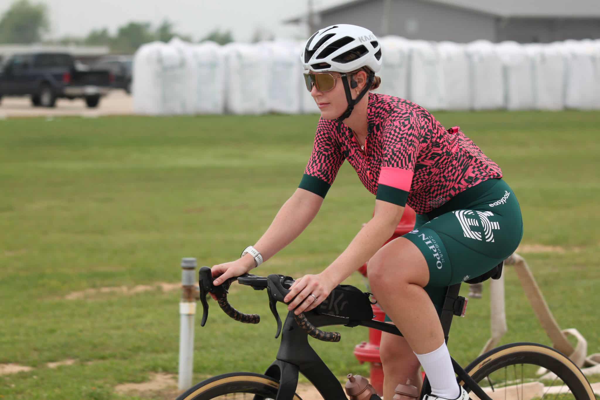 High-performance cyclist riding on outdoor track in professional sports gear.