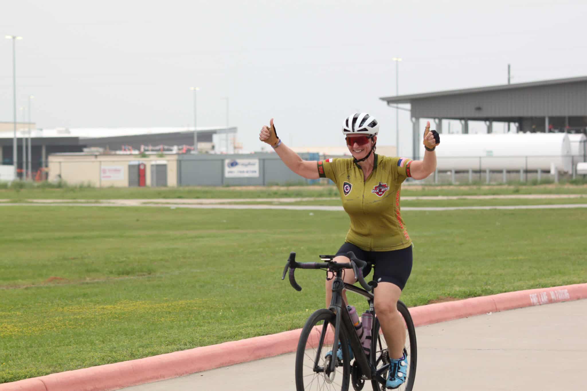 Vibrant cyclist celebrating victory at Bluebonnet Express event, promoting community cycling and outdoor fitness.