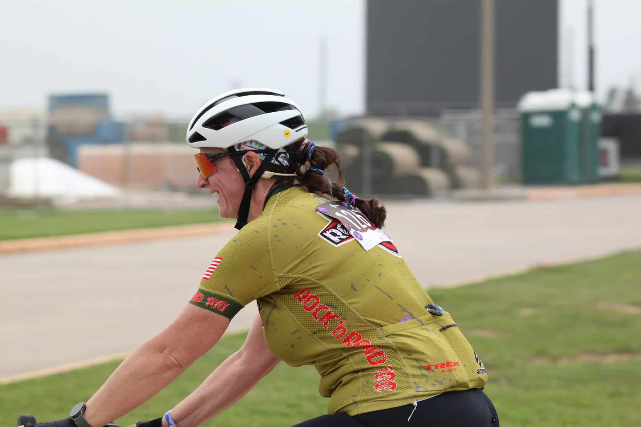 Vibrant cyclist wearing a yellow Rockford OCR jersey, white helmet, and sunglasses during Bluebonnet Express race.